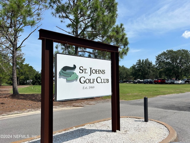 community / neighborhood sign featuring a yard