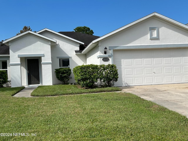 ranch-style home with stucco siding, driveway, a front yard, and an attached garage