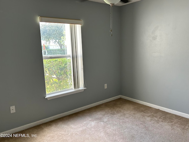 carpeted spare room featuring ceiling fan