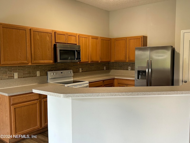 kitchen featuring a textured ceiling, stainless steel appliances, tasteful backsplash, and dark wood-type flooring