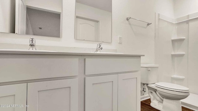 bathroom with wood-type flooring, vanity, toilet, and walk in shower