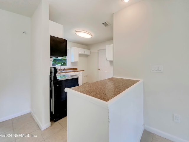 kitchen with kitchen peninsula, white cabinetry, range with electric cooktop, and light tile patterned floors