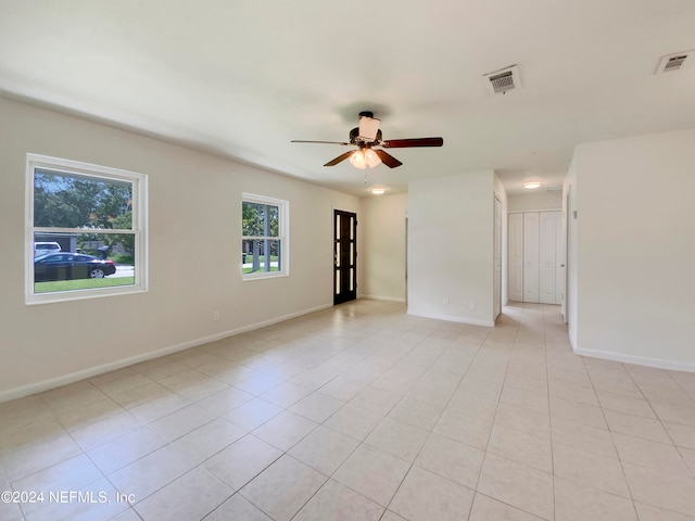 spare room with ceiling fan and light tile patterned floors