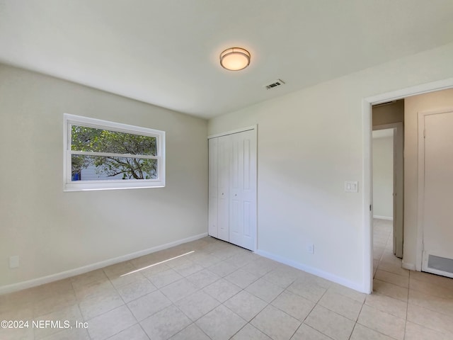 unfurnished bedroom with light tile patterned floors and a closet