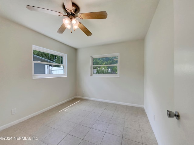 tiled spare room with ceiling fan