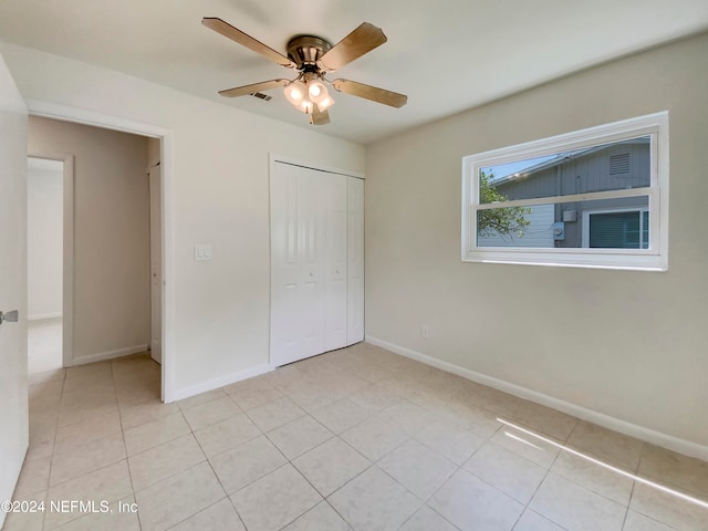 unfurnished bedroom featuring ceiling fan, a closet, and light tile patterned floors