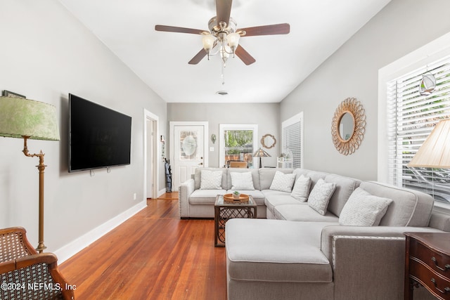 living room featuring ceiling fan and dark wood-type flooring