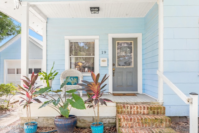 property entrance featuring covered porch and a garage