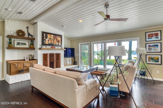 living room featuring ceiling fan, a brick fireplace, plenty of natural light, and dark hardwood / wood-style flooring