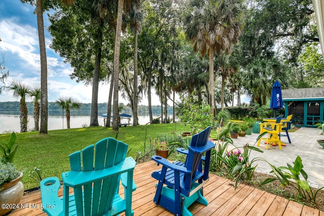 wooden terrace with a lawn and a water view