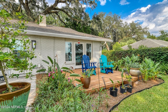 rear view of house featuring a wooden deck