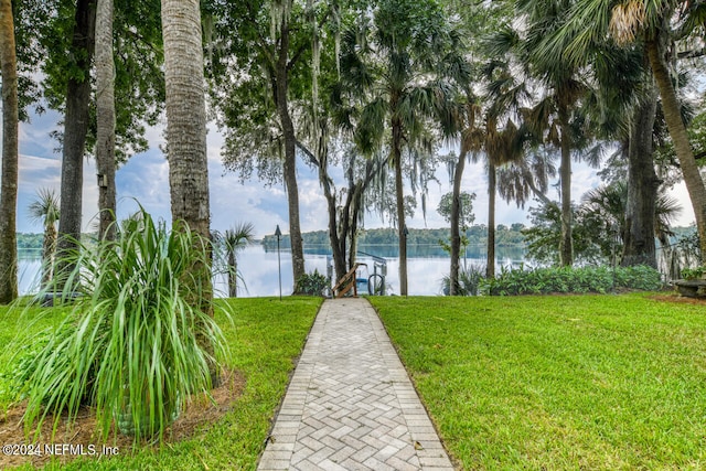 view of property's community with a yard and a water view