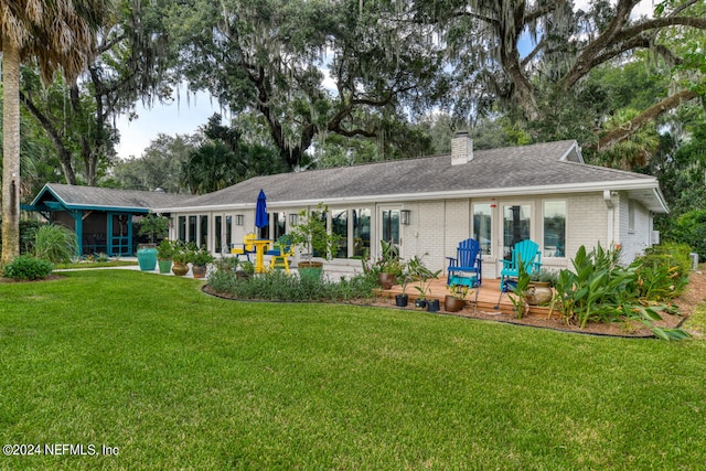 rear view of property featuring a lawn