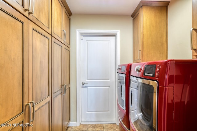 laundry room with separate washer and dryer, light tile patterned floors, and cabinets