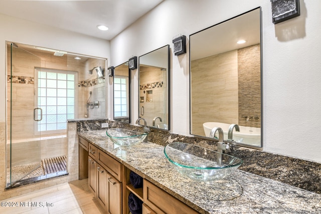 bathroom featuring tile patterned flooring, shower with separate bathtub, and dual bowl vanity