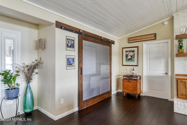 entrance foyer featuring vaulted ceiling, a barn door, crown molding, and dark hardwood / wood-style flooring