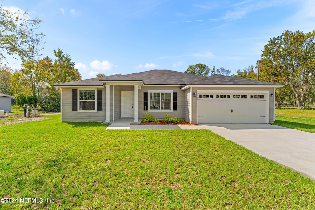 ranch-style house featuring a front lawn and a garage