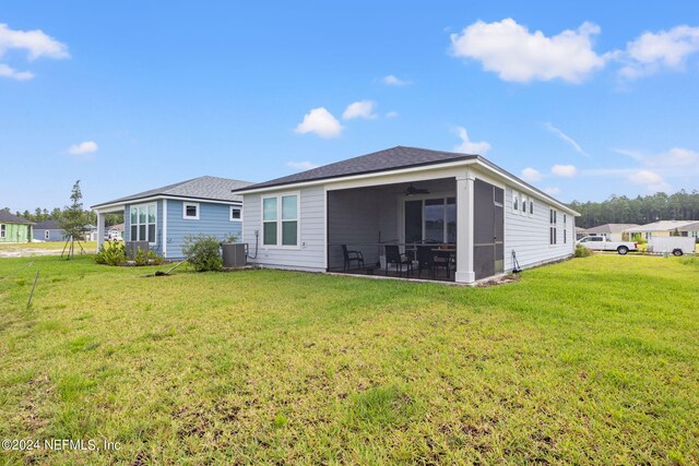 back of property featuring cooling unit and a yard