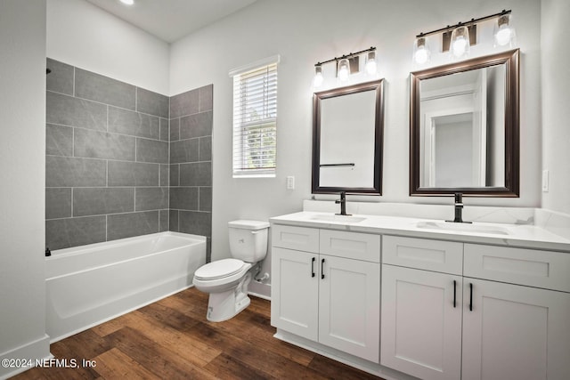 full bath featuring double vanity, toilet, a sink, and wood finished floors