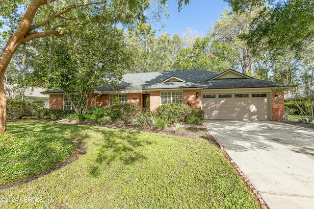 ranch-style home featuring a garage and a front lawn