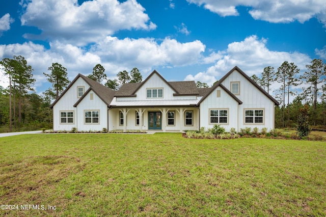 modern farmhouse with french doors, board and batten siding, a standing seam roof, metal roof, and a front lawn