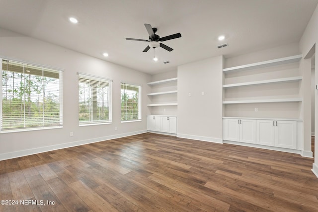 unfurnished living room featuring built in shelves, dark wood finished floors, recessed lighting, visible vents, and baseboards