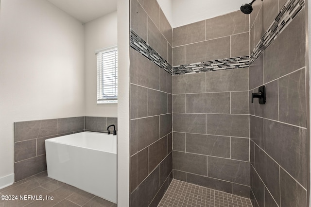 full bath featuring a tub, tiled shower, and tile patterned floors