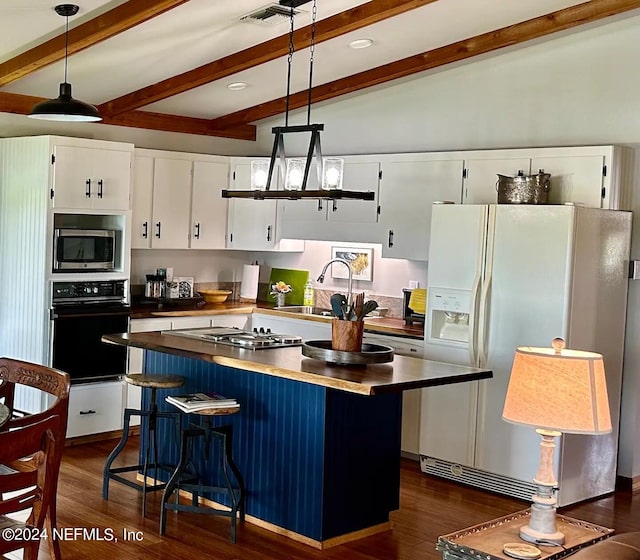 kitchen with stainless steel appliances, white cabinetry, sink, vaulted ceiling with beams, and dark hardwood / wood-style flooring