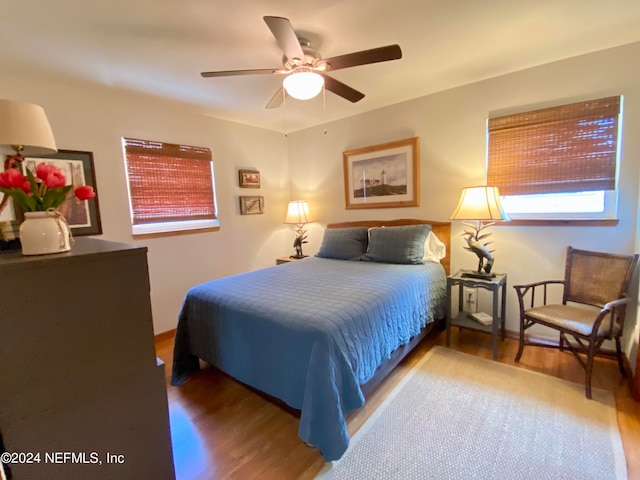 bedroom with ceiling fan and hardwood / wood-style flooring