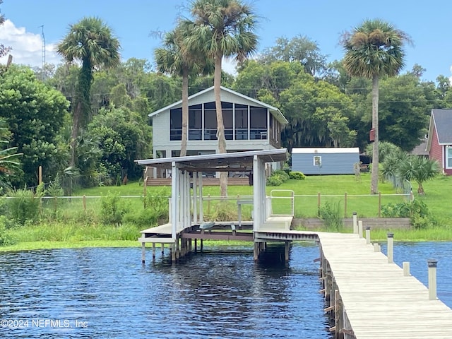 view of dock featuring a lawn and a water view