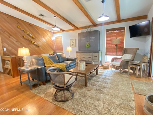 living room with beamed ceiling, hardwood / wood-style flooring, and wooden walls