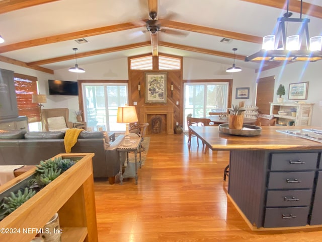 kitchen with plenty of natural light, light hardwood / wood-style floors, and lofted ceiling with beams