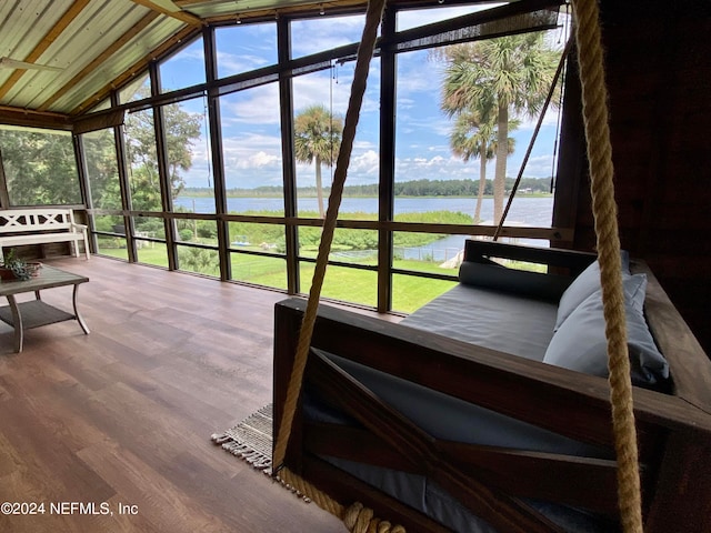 sunroom with vaulted ceiling, a water view, and a healthy amount of sunlight