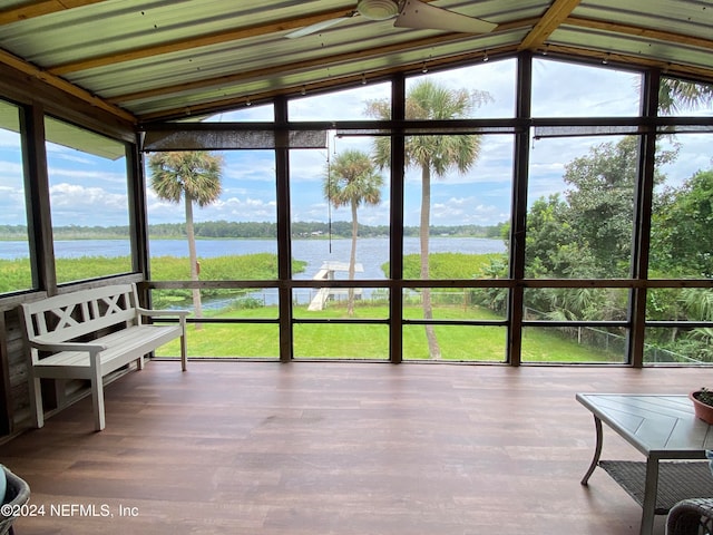 sunroom / solarium with plenty of natural light, ceiling fan, and a water view