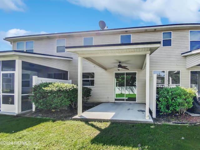 back of house featuring a ceiling fan, a sunroom, a patio area, and a lawn