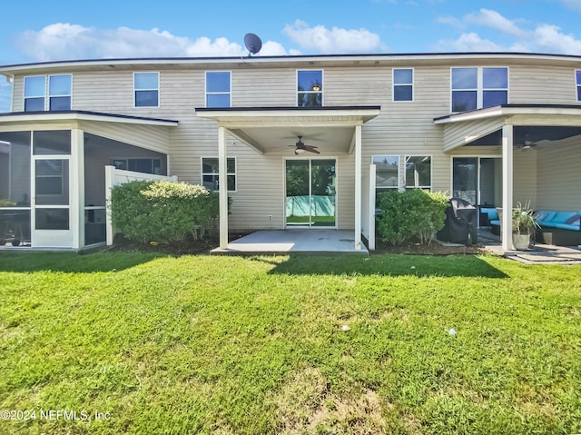 back of property with a yard, a sunroom, a patio, and ceiling fan