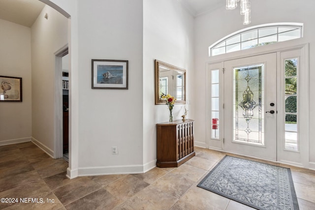 entryway with arched walkways, a towering ceiling, and baseboards