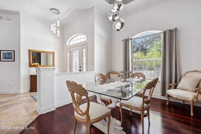 dining room featuring baseboards, ornamental molding, a chandelier, and wood finished floors