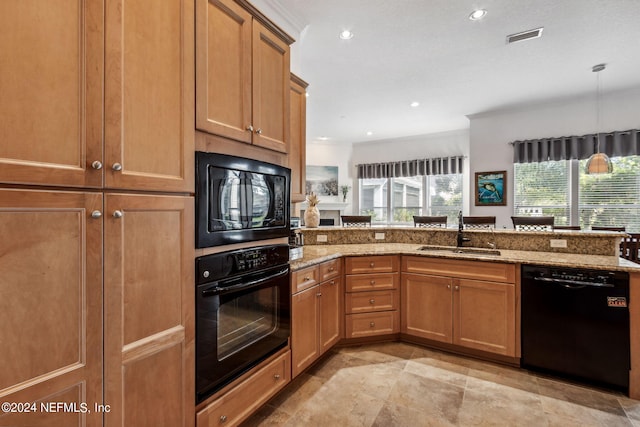 kitchen featuring brown cabinetry, a sink, light stone counters, and black appliances