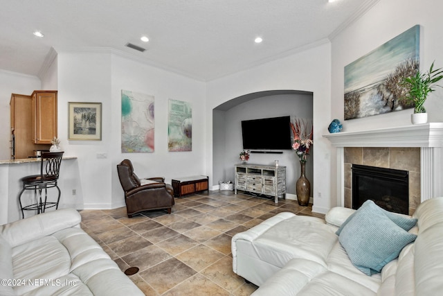 tiled living room featuring ornamental molding and a fireplace