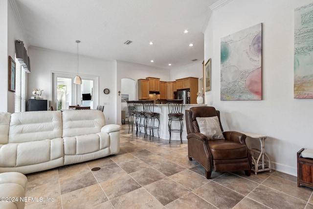 living area with baseboards, visible vents, crown molding, and recessed lighting