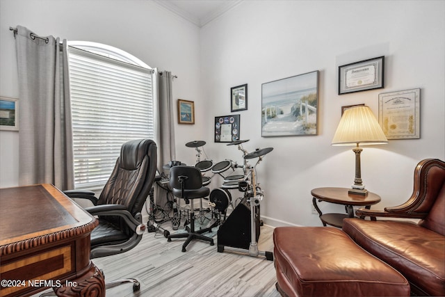 office area featuring baseboards, light wood-type flooring, and crown molding