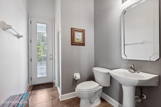 bathroom featuring toilet, tile patterned flooring, and baseboards