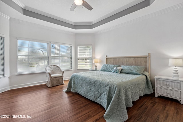 bedroom featuring dark wood-style floors, a raised ceiling, and crown molding