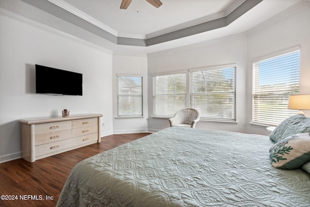 bedroom with ornamental molding, a raised ceiling, dark wood finished floors, and baseboards