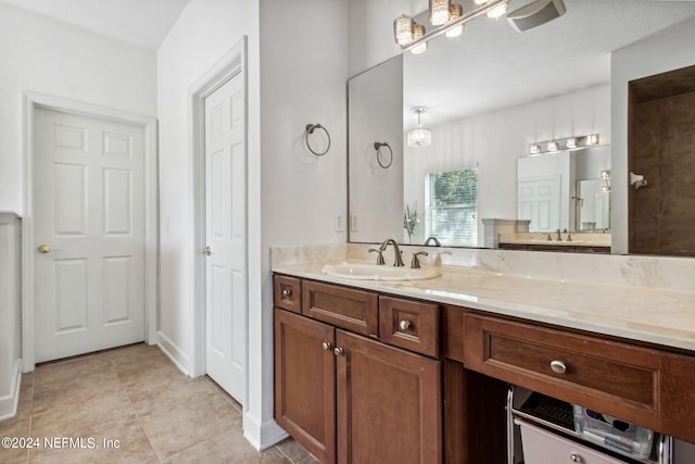 bathroom featuring walk in shower, tile patterned flooring, and vanity