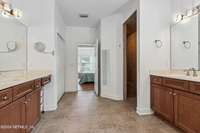 ensuite bathroom with visible vents, a sink, ensuite bath, and tile patterned floors