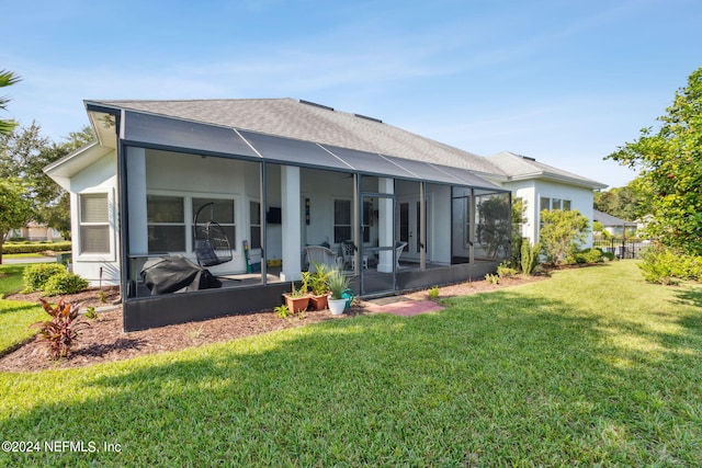 rear view of property featuring a sunroom, glass enclosure, a lawn, and roof with shingles