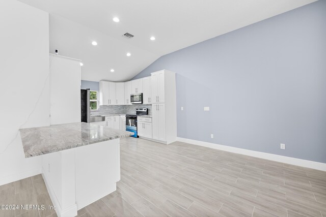 kitchen with backsplash, vaulted ceiling, light stone countertops, kitchen peninsula, and stainless steel appliances