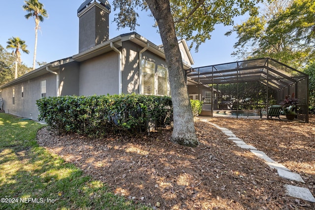 133 Sawmill Lakes Blvd, Ponte Vedra Beach, FL 32082 - view of side of home with a chimney, stucco siding, and a lanai